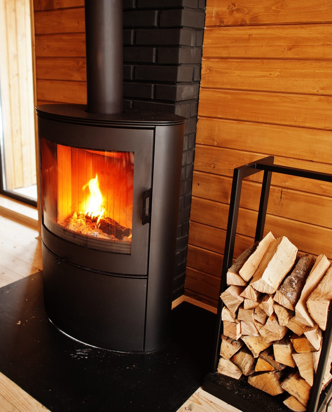 Fireplace with woods in modern wooden house.